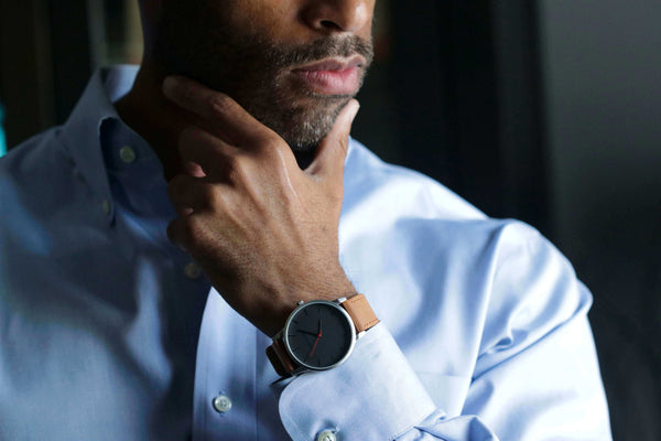 man with hand to chin - matching watch with clothes concept