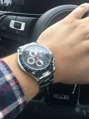 compass tachymeter watch on man's wrist in car