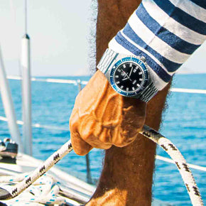 seafarer diver watch on man's wrist holding a line